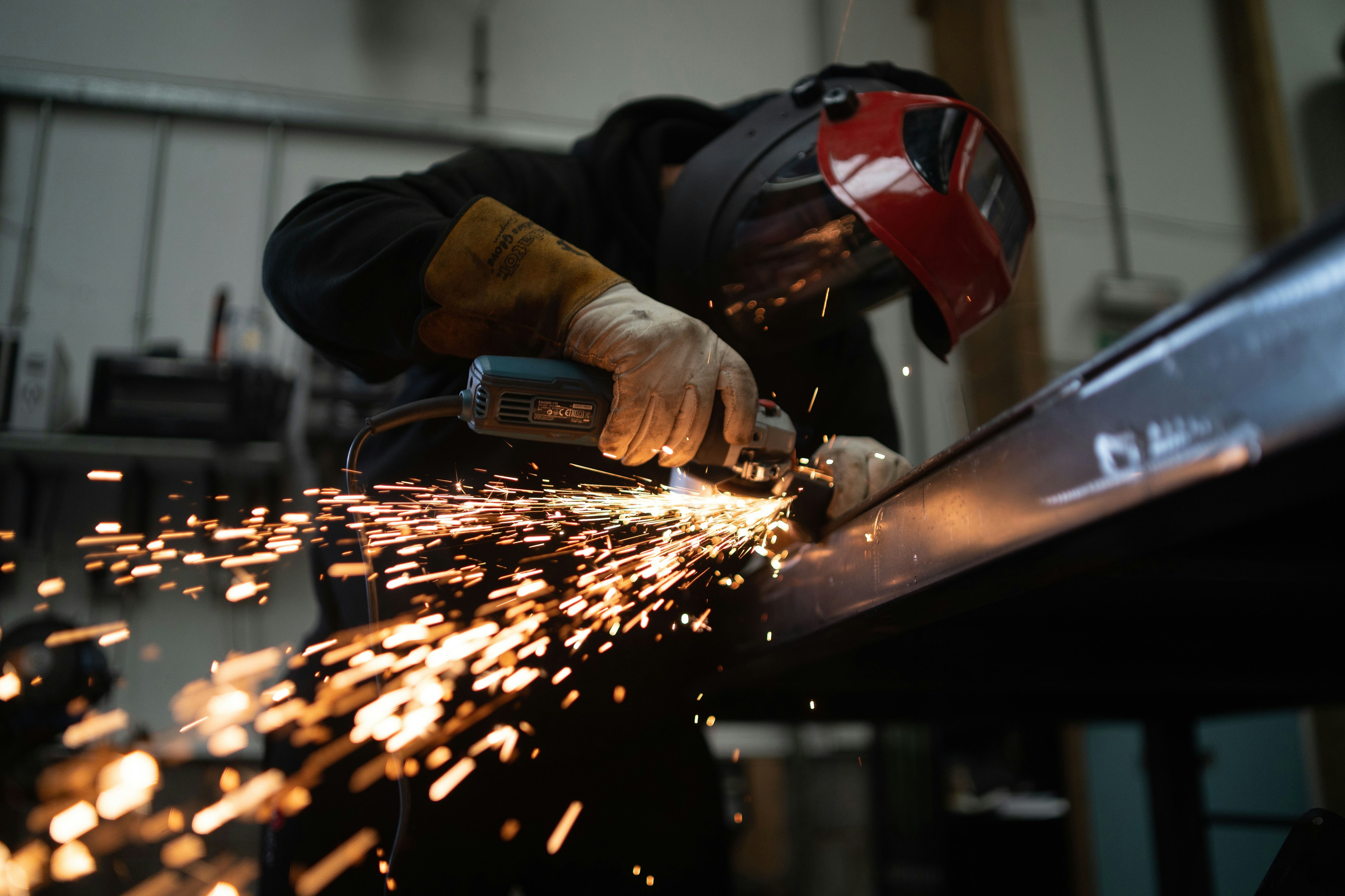 Metal fabricator grinding steel with sparks